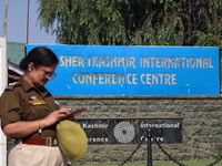 An Indian policewoman stands alert as Jammu and Kashmir and National Conference (NC) Vice President Omar Abdullah arrives to take the oath a...