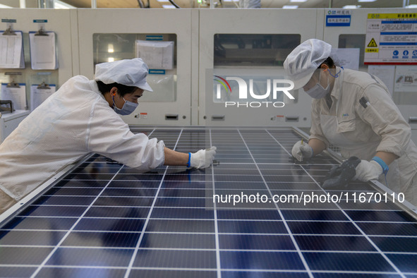 Workers produce solar photovoltaic module products at the workshop of GCL Integrated New Energy Technology Co., Ltd. in Hefei Circular Econo...