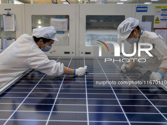 Workers produce solar photovoltaic module products at the workshop of GCL Integrated New Energy Technology Co., Ltd. in Hefei Circular Econo...