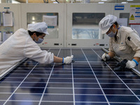 Workers produce solar photovoltaic module products at the workshop of GCL Integrated New Energy Technology Co., Ltd. in Hefei Circular Econo...