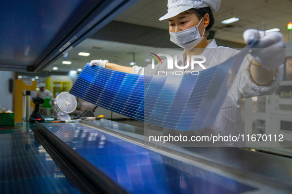 Workers produce solar photovoltaic module products at the workshop of GCL Integrated New Energy Technology Co., Ltd. in Hefei Circular Econo...