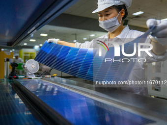 Workers produce solar photovoltaic module products at the workshop of GCL Integrated New Energy Technology Co., Ltd. in Hefei Circular Econo...