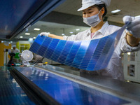 Workers produce solar photovoltaic module products at the workshop of GCL Integrated New Energy Technology Co., Ltd. in Hefei Circular Econo...