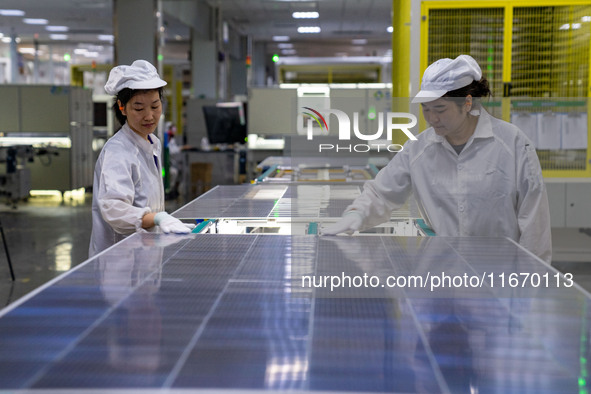 Workers produce solar photovoltaic module products at the workshop of GCL Integrated New Energy Technology Co., Ltd. in Hefei Circular Econo...