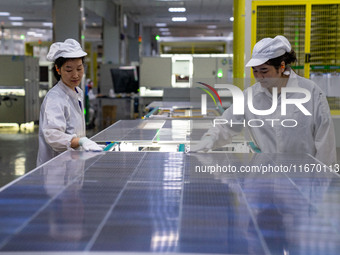 Workers produce solar photovoltaic module products at the workshop of GCL Integrated New Energy Technology Co., Ltd. in Hefei Circular Econo...