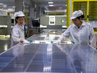 Workers produce solar photovoltaic module products at the workshop of GCL Integrated New Energy Technology Co., Ltd. in Hefei Circular Econo...