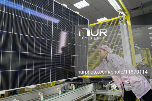 Workers produce solar photovoltaic module products at the workshop of GCL Integrated New Energy Technology Co., Ltd. in Hefei Circular Econo...