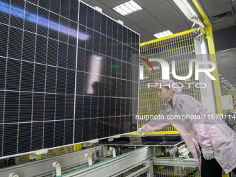 Workers produce solar photovoltaic module products at the workshop of GCL Integrated New Energy Technology Co., Ltd. in Hefei Circular Econo...