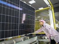 Workers produce solar photovoltaic module products at the workshop of GCL Integrated New Energy Technology Co., Ltd. in Hefei Circular Econo...