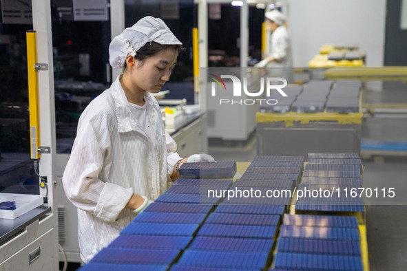 Workers produce solar photovoltaic module products at the workshop of GCL Integrated New Energy Technology Co., Ltd. in Hefei Circular Econo...