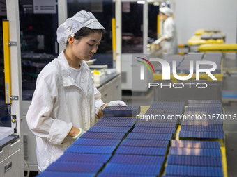 Workers produce solar photovoltaic module products at the workshop of GCL Integrated New Energy Technology Co., Ltd. in Hefei Circular Econo...