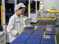 Workers produce solar photovoltaic module products at the workshop of GCL Integrated New Energy Technology Co., Ltd. in Hefei Circular Econo...