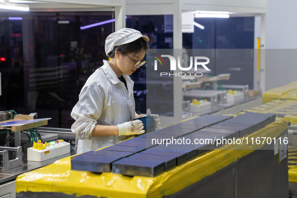 Workers produce solar photovoltaic module products at the workshop of GCL Integrated New Energy Technology Co., Ltd. in Hefei Circular Econo...