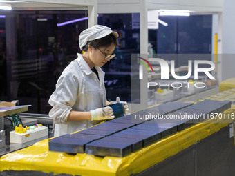 Workers produce solar photovoltaic module products at the workshop of GCL Integrated New Energy Technology Co., Ltd. in Hefei Circular Econo...