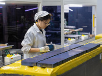 Workers produce solar photovoltaic module products at the workshop of GCL Integrated New Energy Technology Co., Ltd. in Hefei Circular Econo...