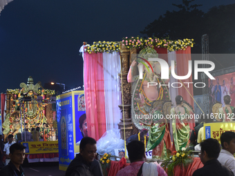 People participate in a procession with Durga idols before the immersion of the statue of Goddess Durga into the river Ganges as part of the...