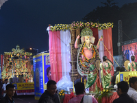 People participate in a procession with Durga idols before the immersion of the statue of Goddess Durga into the river Ganges as part of the...