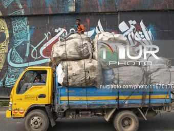 People walk past Arabic calligraphy in Dhaka, Bangladesh, on October 14, 2024. (