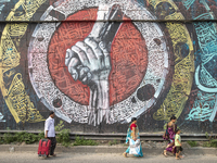 People walk past Arabic calligraphy in Dhaka, Bangladesh, on October 14, 2024. (