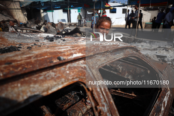 A displaced Palestinian girl looks out from a destroyed car due to an Israeli airstrike on the tents of the displaced inside the Al-Aqsa Mar...