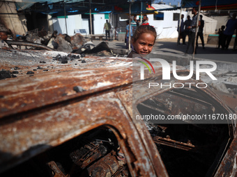 A displaced Palestinian girl looks out from a destroyed car due to an Israeli airstrike on the tents of the displaced inside the Al-Aqsa Mar...