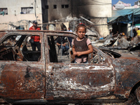 A displaced Palestinian girl looks out from a destroyed car due to an Israeli airstrike on the tents of the displaced inside the Al-Aqsa Mar...