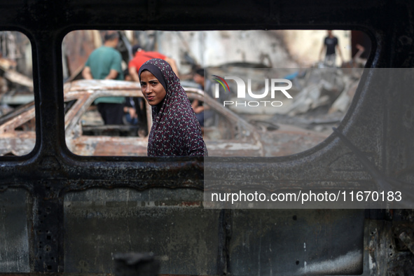 A displaced Palestinian girl looks out from a destroyed car due to an Israeli airstrike on the tents of the displaced inside the Al-Aqsa Mar...