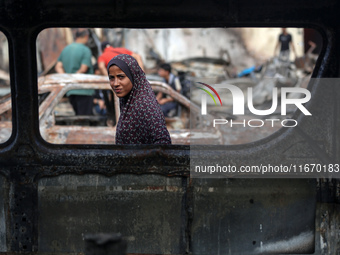 A displaced Palestinian girl looks out from a destroyed car due to an Israeli airstrike on the tents of the displaced inside the Al-Aqsa Mar...