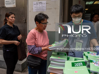 A woman receives a copy of the 2024 Policy Address in Hong Kong, China, on October 16, 2024. The Hong Kong Chief Executive John Lee announce...