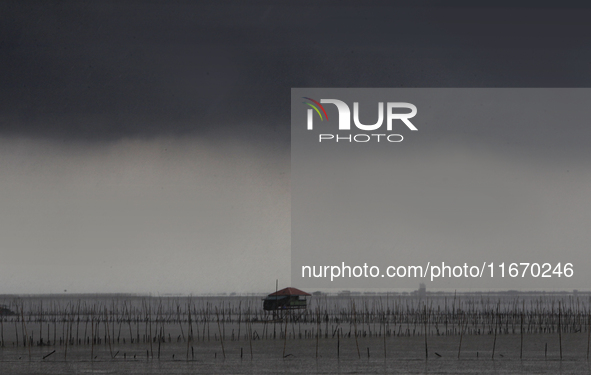 Rain clouds gather over a cottage in Chonburi province, east of Bangkok, on October 16, 2024. 