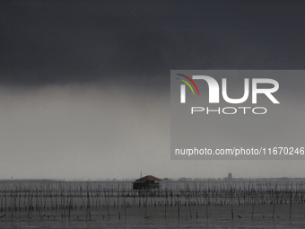 Rain clouds gather over a cottage in Chonburi province, east of Bangkok, on October 16, 2024. (