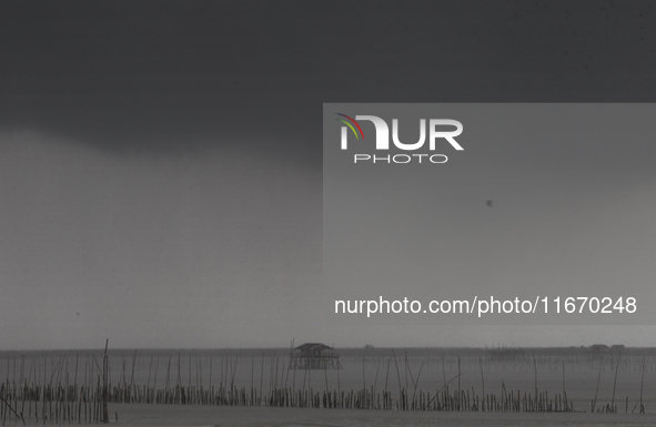 Rain clouds gather over a cottage in Chonburi province, east of Bangkok, on October 16, 2024. 