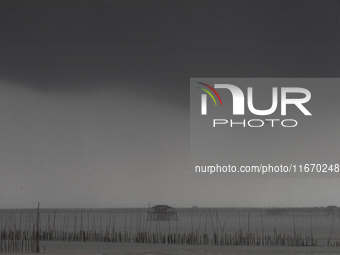 Rain clouds gather over a cottage in Chonburi province, east of Bangkok, on October 16, 2024. (