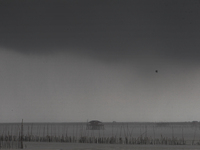 Rain clouds gather over a cottage in Chonburi province, east of Bangkok, on October 16, 2024. (