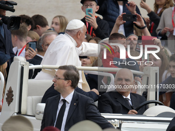 Pope Francis caresses a baby from his popemobile as he arrives for the weekly general audience at Saint Peter's Square in The Vatican on Oct...