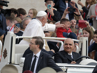 Pope Francis caresses a baby from his popemobile as he arrives for the weekly general audience at Saint Peter's Square in The Vatican on Oct...