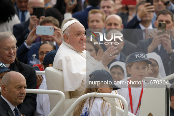 Pope Francis waves to the crowd from the popemobile as he arrives for the weekly general audience at Saint Peter's Square in The Vatican on...