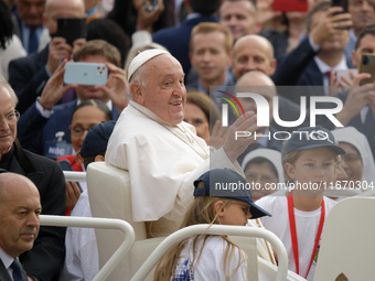 Pope Francis waves to the crowd from the popemobile as he arrives for the weekly general audience at Saint Peter's Square in The Vatican on...