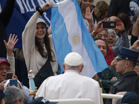 A pilgrim waves the Argentine flag when Pope Francis arrives in St. Peter's Square in Vatican City, on October 16, 2024, for the weekly gene...