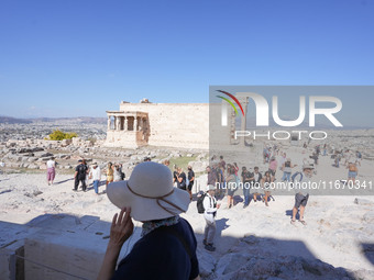 Tourists visit the Acropolis Hill in Athens, Greece, on October 16, 2024. (