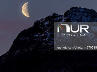 A view of waning crescent moon over the snowy mountains of Tromso, Norway on September 25, 2024.  (