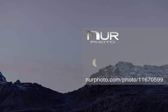 A view of waning crescent moon over the snowy mountains of Tromso, Norway on September 25, 2024.  