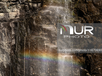 A rainbow appears through the mist of a waterfall cascading down the cliffs in Geiranger Fjord, Norway, on September 18, 2024.  Geiranger Fj...