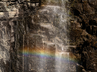 A rainbow appears through the mist of a waterfall cascading down the cliffs in Geiranger Fjord, Norway, on September 18, 2024.  Geiranger Fj...