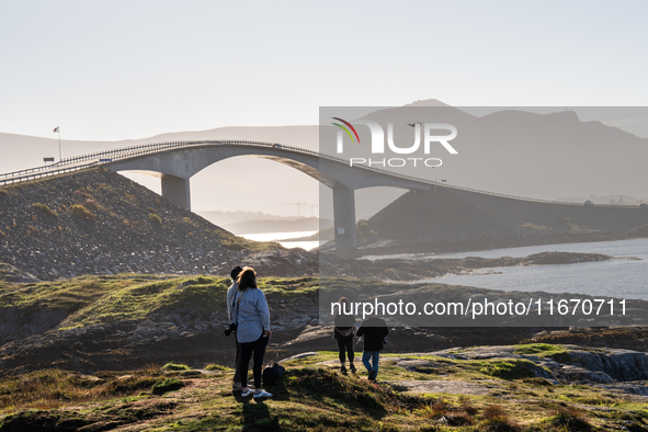 Tourists walk along a scenic pathway near a bridge on the Atlantic Ocean Road in Norway, on September 18, 2024. The Atlantic Road in Norway...