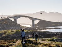 Tourists walk along a scenic pathway near a bridge on the Atlantic Ocean Road in Norway, on September 18, 2024. The Atlantic Road in Norway...