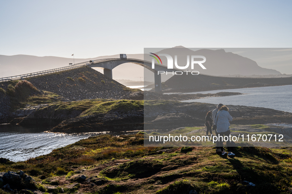 Tourists walk along a scenic pathway near a bridge on the Atlantic Ocean Road in Norway, on September 18, 2024. The Atlantic Road in Norway...