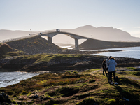 Tourists walk along a scenic pathway near a bridge on the Atlantic Ocean Road in Norway, on September 18, 2024. The Atlantic Road in Norway...