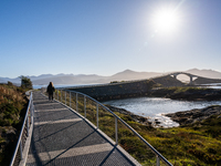 Tourists walk along a scenic pathway near a bridge on the Atlantic Ocean Road in Norway, on September 18, 2024. The Atlantic Road in Norway...