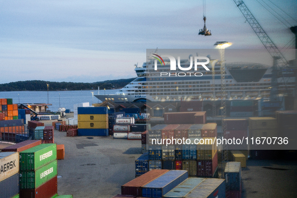 Shipping containers are stacked at the port in Kristiansand, Norway, with the AIDA Cruises ship docked in the background on September 12, 20...